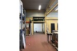 Lagerhalle mit überdachter Ladezone und großem Außenbereich.